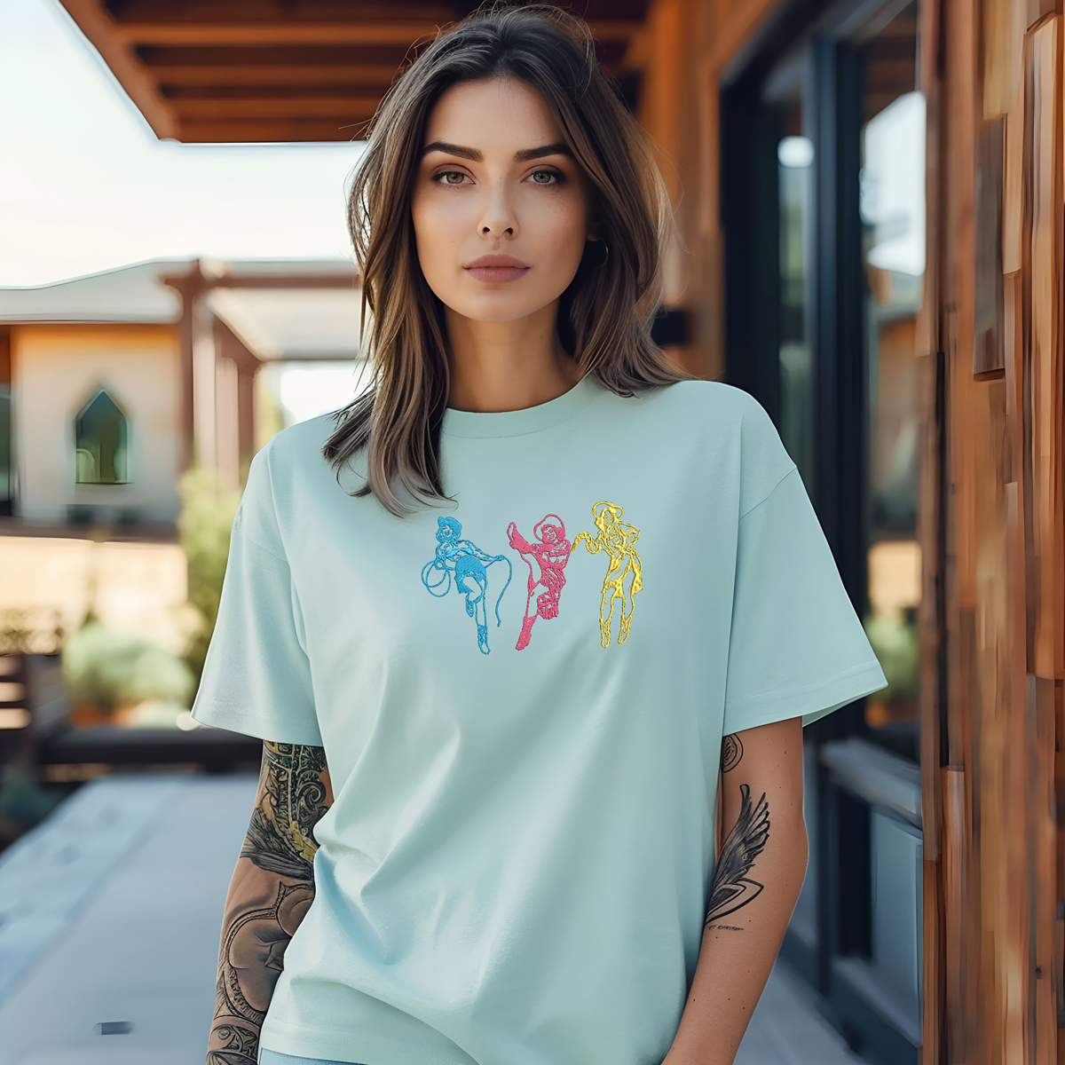 teal t shirt with three cowgirls embroidered on it
