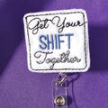 A badge reel with a square attachment featuring the text 'Get Your Shift Together' on a purple background.
